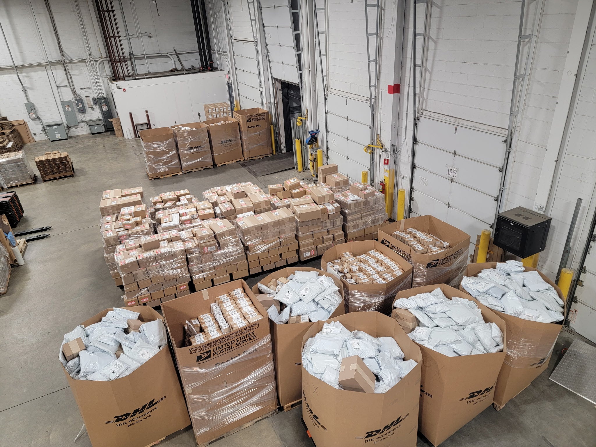 Packed orders and carrier containers staged at warehouse loading docks